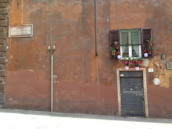 street shot with a single door and window that look super urban enriched with the art of rome