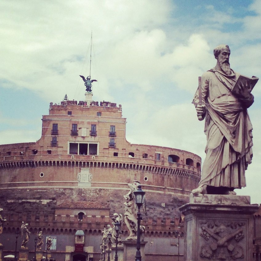 Entrance of Sant'Angelo in center of rome, statue reading a book representing a priest
