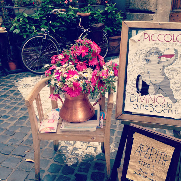 Aperitif sign with chair and a flower pot welcoming tourists at compo di fiori