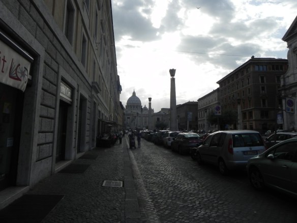 a black and white photograph of the pathway to the Vatican city in rome during sun dawm
