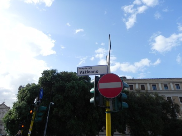 A street sign of the Vatican in Rome Italy with a no parking sign under a great blue sky