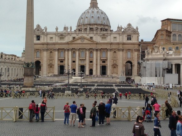 st peters Basilica square at the vatican city with people waiting in lone and the cross is apparent beautiful architecture  