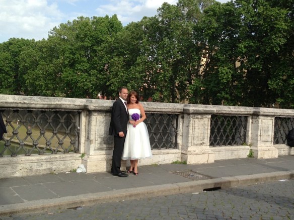 a wedding at the castel saint'angelo bride and groom being photographed nearby the bridge