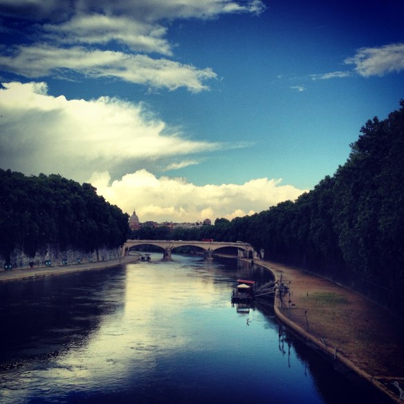 one of my favorite photos of rome with blue blue skies reflection on the blue river and the green long trees on the side travelblog