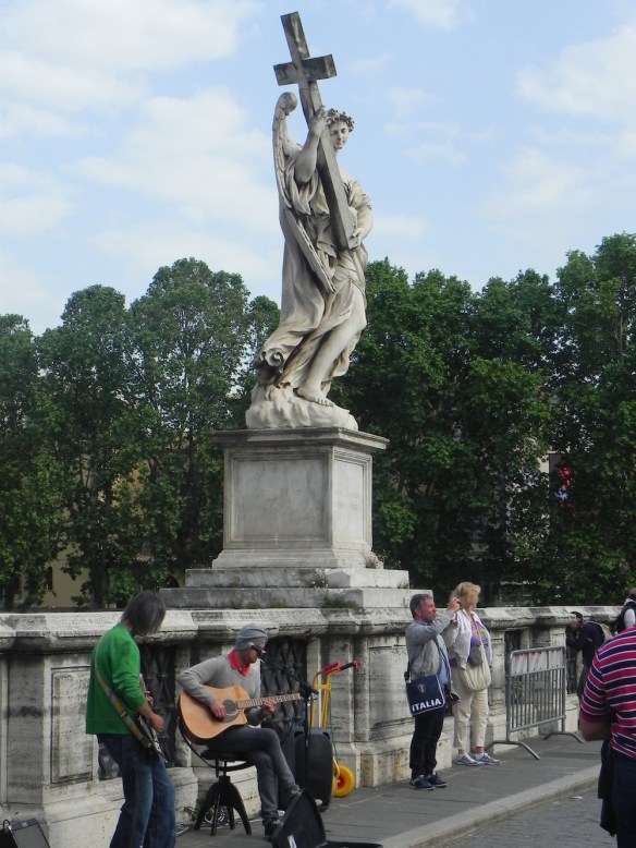 one of the statues at the saint angelo carrying a cross 
