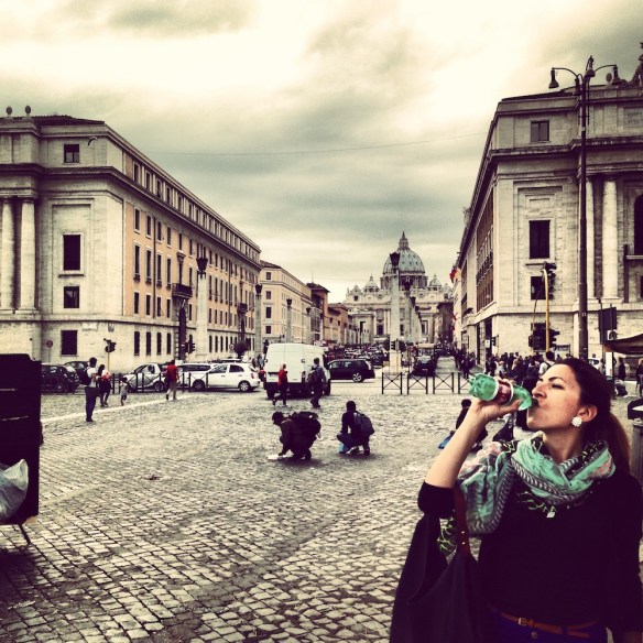 after a long walk i am drinking water from thirst in the streets of the vatican city rome 
