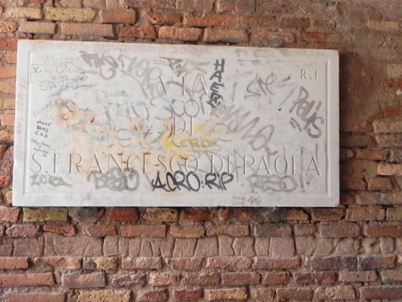 Street sign that is covered with graffiti in rome