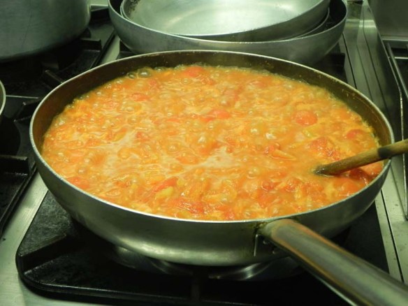 Making and cooking tomato sauce for the appetizer dish in cookingclass Rome