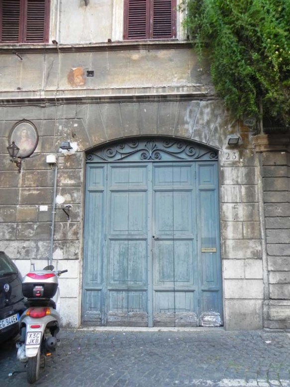 A very big garage or door with a motorbike parking right infront of it Rome