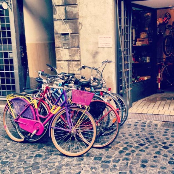 multiple colored bikes on the entrance of a bike shop