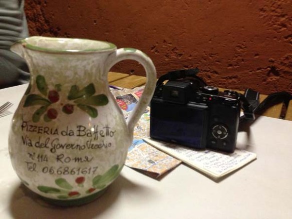 tourists table with a jug of wine maps and professional camera