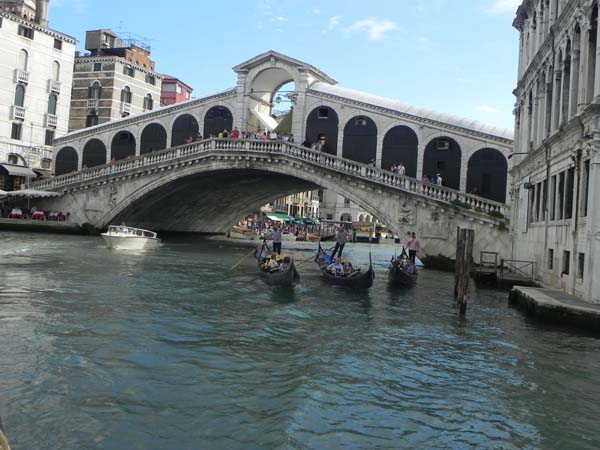 A gondola and a gondolier at the Grand Canal under bridge venice venezia