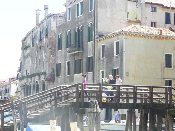 Old man with flower and woman with stroller enjoying the sunlight