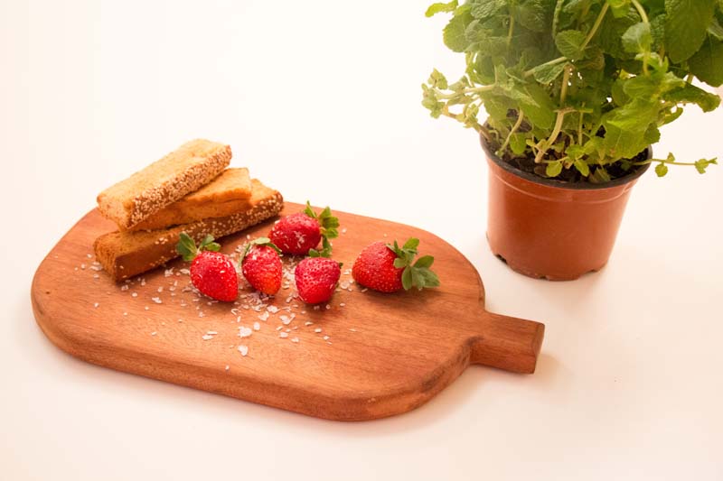 Strawberries in a wood mat and some green plants