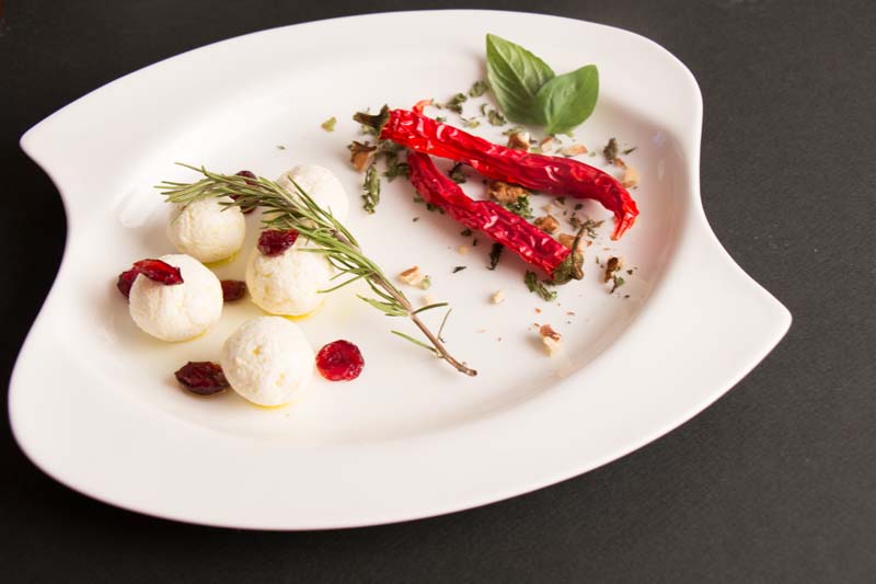 a dish of labaneh balls and red dried chilli pepper