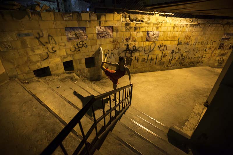 A balet dancer in a ghetto area under yellow light webdeh amman jordan