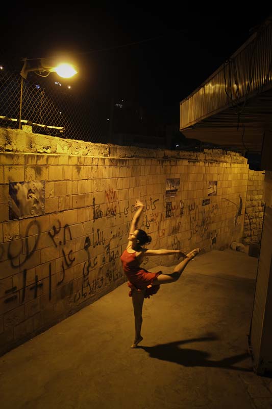 A balet dancer in a ghetto area under yellow light webdeh amman jordan