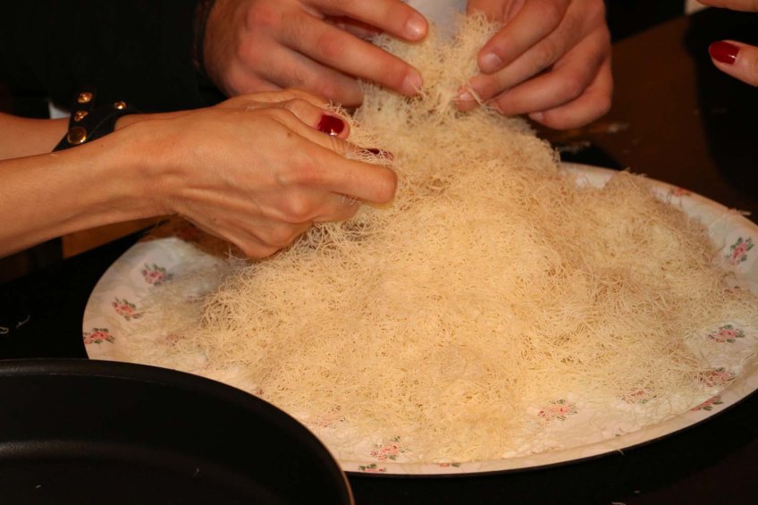 Making Palestinian dessert knafeh