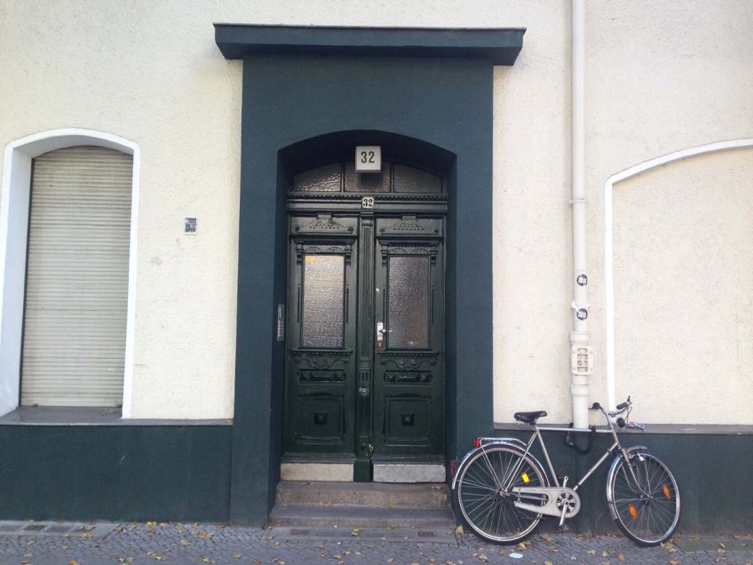 Bicycle with a beige and blue door wall in berlin