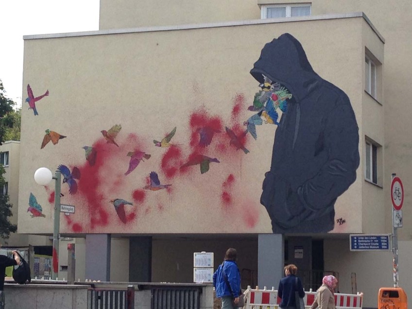 Graffiti with man blowing butterflies from his mouth