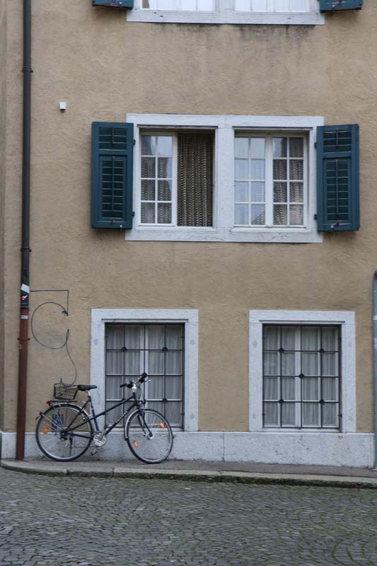 Bike parked at a beige building and green fenetre in solothurn switzerland