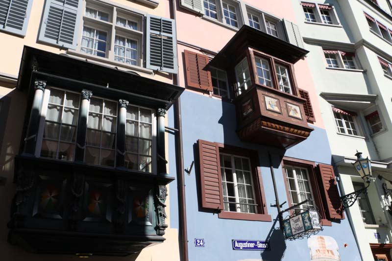 A photo of guild houses in Zurich brown blue and pink architecture from the 1336